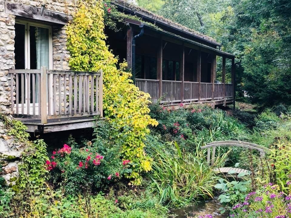 Balcon en bois et jardin fleuri du Moulin de Lonceux